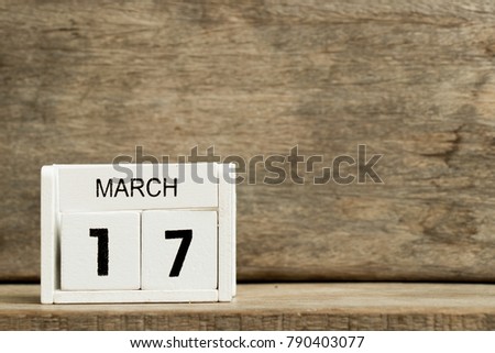 White block calendar present date 17 and month March on wood background