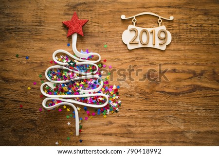 Sigh symbol Christmas Tree from a lot colorful confetti, lace and red star toy on old retro vintage style wooden texture background Empty copy space for inscription Idea of merry new year 2019 holiday
