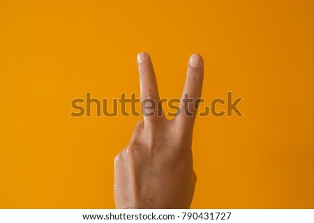 Hand male caucasian gestures  the yellow background.

