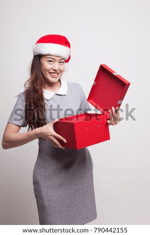 Young Asian woman open a golden gift box on gray background