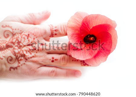 Hindu pattern on female hand and red flower tropical hibiscus. Body painting in Indian style, language of flowers, symbol of universal love, appeal to Lakshmi for happiness, female ornamentation