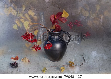 Autumn still life berries fireplaces, yellow leaves in a vase on a brown background