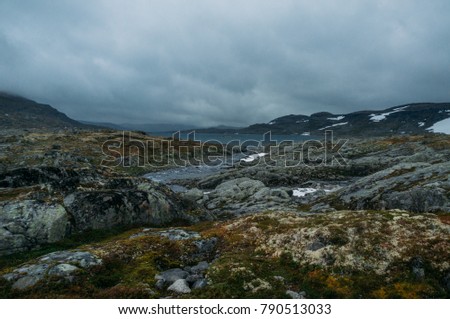 view of rocky terrain with lake on background surrounded by hills, Norway, Hardangervidda National Park