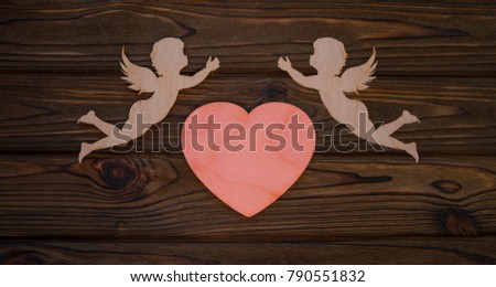 two cupids and a heart made from wood texture background. The holiday of lovers. Valentine's Day. space for text and design