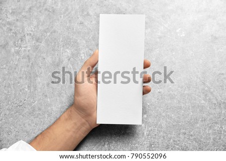 Man holding blank card on grey background. Mock up for design