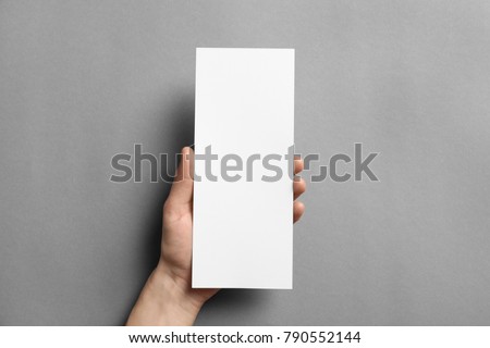 Woman holding blank card on grey background. Mock up for design