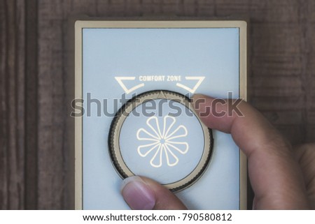 Close up of hand adjusting gauge with western scrips lettering Comfort Zone