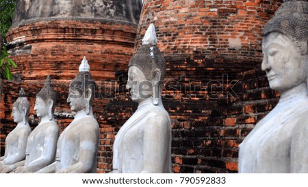 Four of ancient pagodas are Ayutthaya, Thailand. This has blue sky be background and ground on foreground of picture.