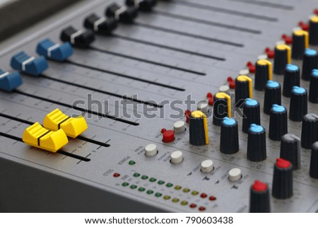 Close up audio control sound mixing console board with fader bars, buttons and sliders, high angle view