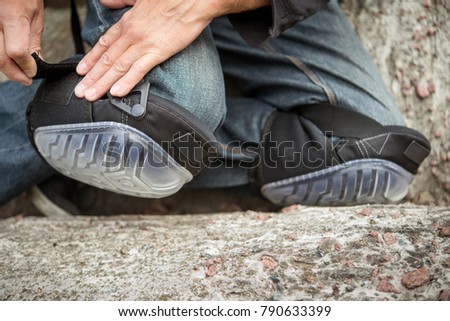 man fastens the knee with a protector for the worker Royalty-Free Stock Photo #790633399