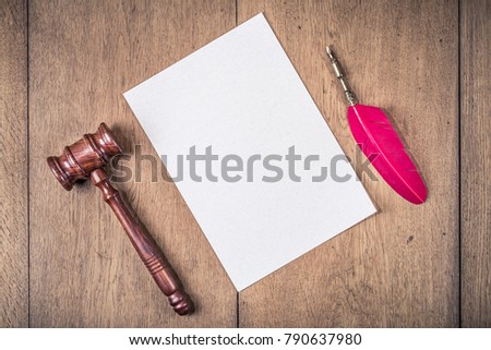 Auction or judge gavel, vintage red quill ink pen and textured paper blank on wooden table background. Retro old style filtered photo