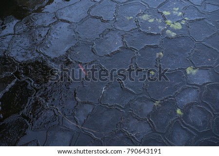 Beautiful details of pattern and texture of frozen ice in lake at winter. Nice background photo with calm blue color