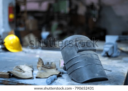 Equipment technician welding helmets and glove in factory. Setup studio shooting.