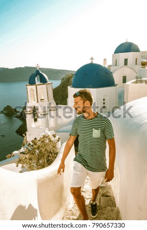 Santorini Oia Greece  Young man looking out over the village on a bright summer day 
