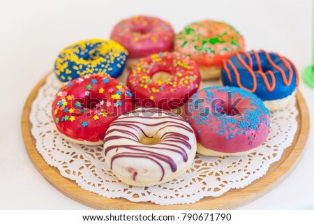 Picture of assorted donuts in a box with chocolate frosted, pink glazed and sprinkles donuts