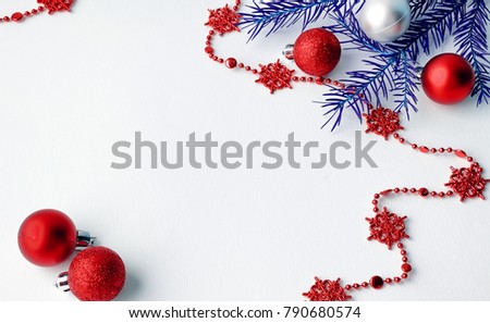 Christmas tree toys on a white background. Christmas decorations on a white surface. Balls and garland of red and silver colors on the table.