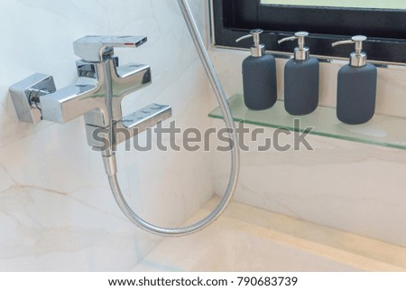 close up of bathtub faucet with three bottle of hygiene liquid such as shampoo,bath gel, conditioner.