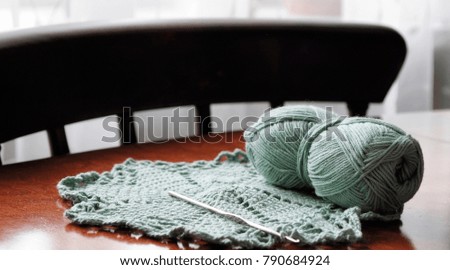 Clumps of yarn and knitting needles on the table in the room