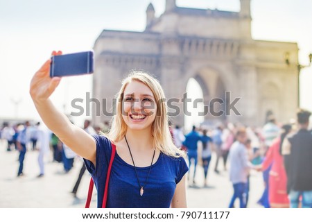 Happy woman taking selfie in front of Gateway of India  Royalty-Free Stock Photo #790711177