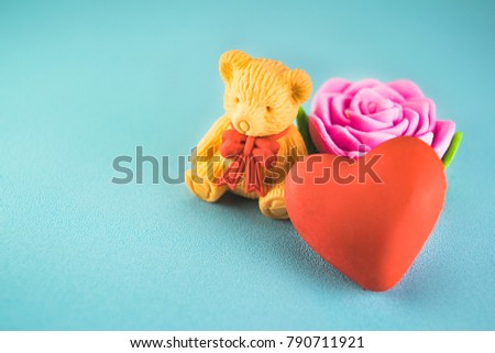 Red hearts,bear and pink rose on a blue plastic background style soft for Valentine's day. Selective focus.