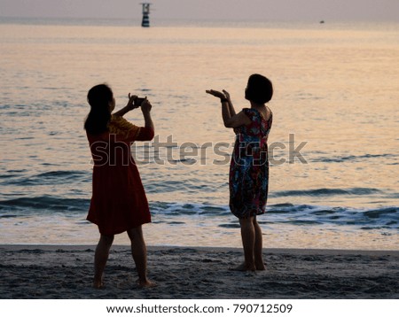 Travelers take photo with smartphone at the beach.