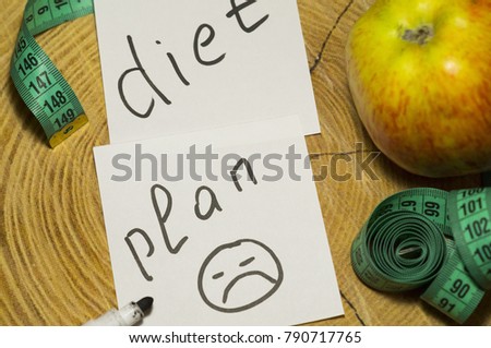 Healthy eating. Apple, centimeter and a sticker with the inscription "diet plan" and a dirty smear