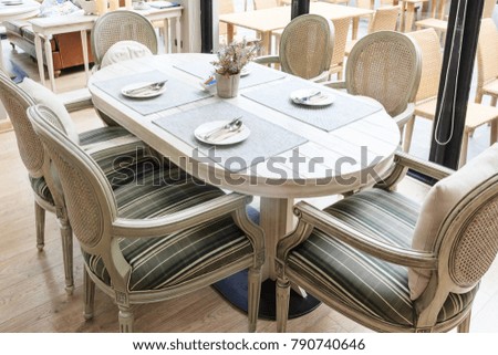 Setting the table for dining room, the table is decorated with plant, whole scene is sunlight