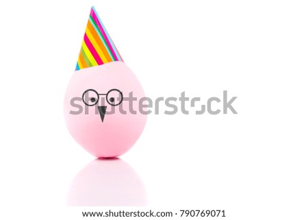 Funny handmade egg in cap isolated on white . Easter holiday.