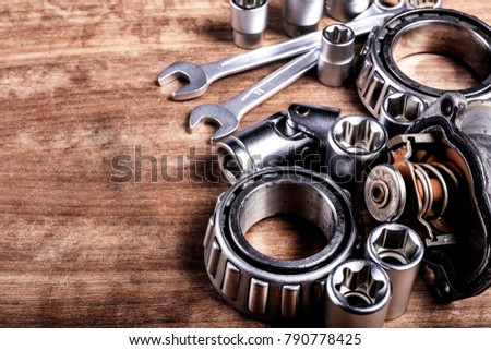 tools and old auto parts on wooden background
