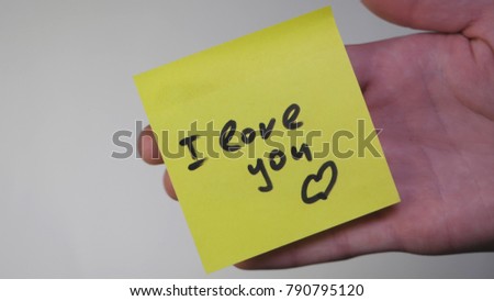 Drawing i love you on yellow paper. Inscription on the sticker I love you on white background