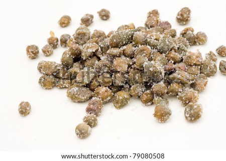 Capers under salt from the island of Pantelleria on a white background