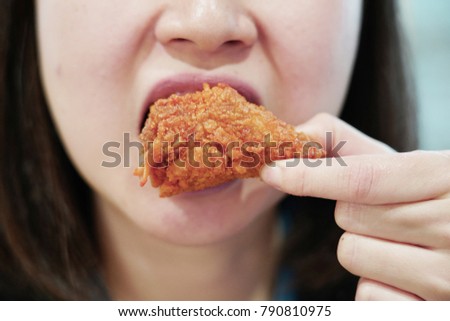 Asian woman eating crispy fried chicken
