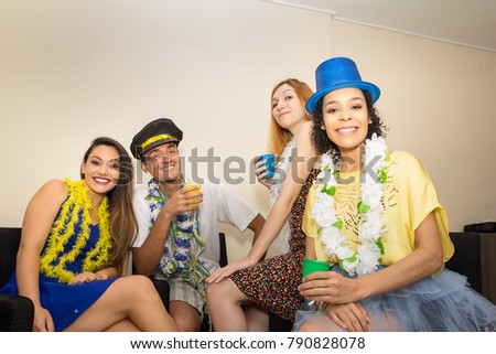 Multi ethnic group of friends are making Carnaval party. Euphoria in Brazil. They are wearing costumes. Revelers are smiling and looking forward.