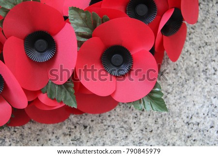 A poppy wreath on a war memorial, as used on Remembrance Day, Memorial Day, or ANZAC Day Royalty-Free Stock Photo #790845979