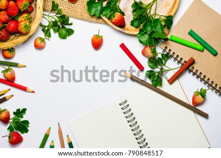 Beautifully decorated strawberries on a white background with wood and paper colors to compose messages to make them interesting.
