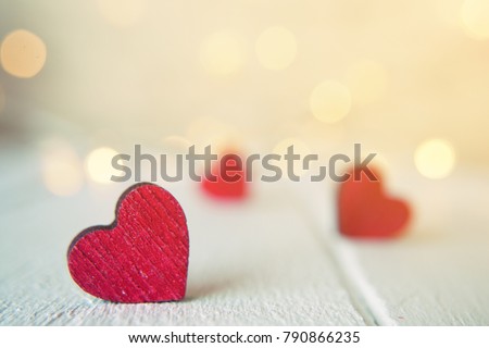 Close up of red hearts on wooden table against defocused lights. St. Valentine's Day background