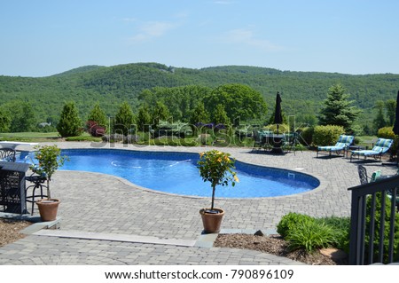 Summer In Ground Pool and Patio Scene with Lush Well Manicured Landscaping, High End Real Estate, Wealth or Vacation/Villa, Lifestyle Concepts, Let's Get Ready for Summer and Entertaining Royalty-Free Stock Photo #790896109