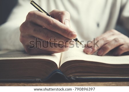 man reading book hand pen  on table background