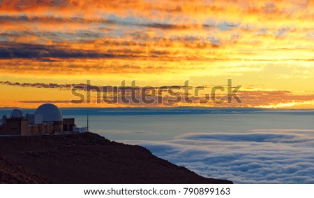 Full color sunset over a sea of clouds, foreground in shade, cloud pattern, research station at the edge of the picture - Location: Hawaii, Maui Island, Haleakala Volcano (Haleakal?)              