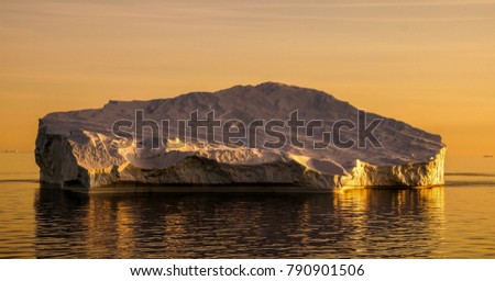 Iceberg drifting in the ocean during Sunset in Greenland.