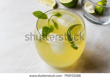 Yellow Lemonade Cocktail with Lime and ice.