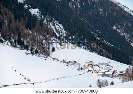 Snow-covered mountain village at the foot of the mountain in winter afternoon, ski resort Ischgl Tyrol Alps