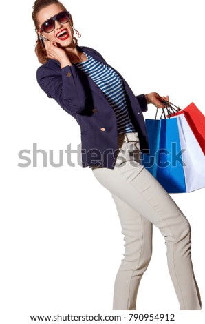 Luxury Shopping. The French way. happy young woman with shopping bags in sunglasses talking on a smartphone and walking isolated on white