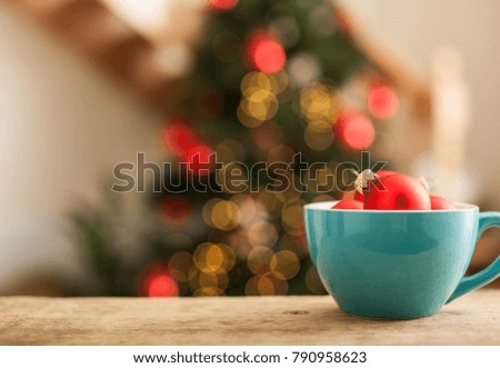 Two red Christmas balls near New Year Tree Branch in blue cup and on blur background of red wall. New Year Time, Christmas Theme