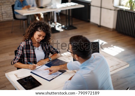 Young woman signing contract with manager