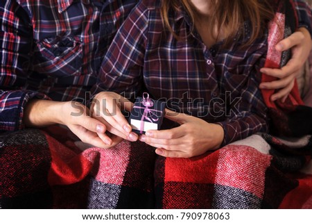 Top view picture of male and female hand with gift box. valentine day family celebration concept. Lovers warmed by a warm blanket for the holidays.