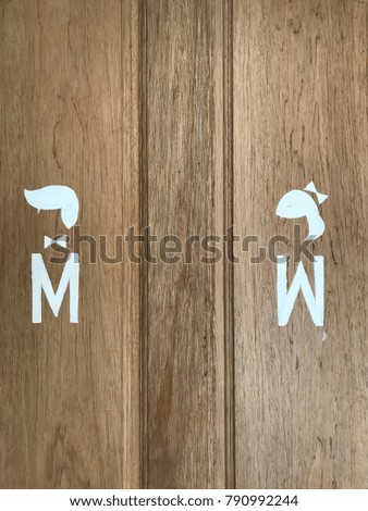 The gender sign on the wooden door