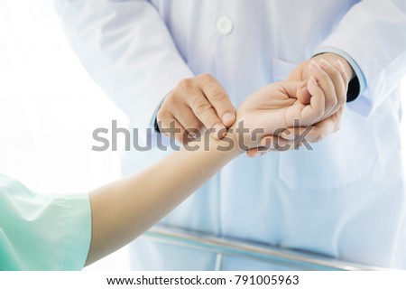 Doctor with patient. Routine health check and holding hands. Male medical doctor with young chinese woman. Royalty-Free Stock Photo #791005963