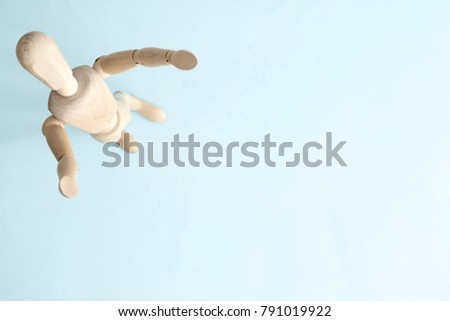 A studio photo of a wooden toy mannequin