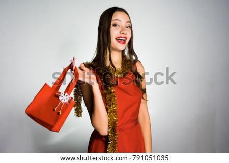 happy girl in a beautiful red dress with a bag in hands